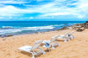 three lounge chairs on a beach with the ocean at Condado Ocean Club - Adults Only in San Juan