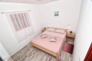 Un pequeño dormitorio con una cama rosa y una ventana en STUDIO APARTMAN EDY 3, en Pula