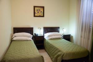 two beds in a hotel room with at Bellavigna Country House in Montefalcione