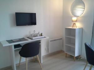 een kamer met een bureau, een televisie en stoelen bij Résidence Le poisson d'or in Perros-Guirec