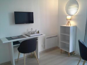 a room with a desk with a television and chairs at Résidence Le poisson d'or in Perros-Guirec