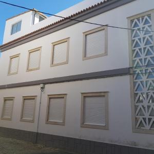 ein weißes Gebäude mit braunen Fenstern darauf in der Unterkunft DREAMS HOUSE in Faro