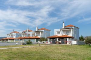 een groot wit gebouw met een gazon ervoor bij Alkion Villa in Gennadi