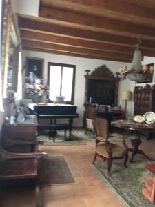 a living room with a piano and a table at Casa Madonna Boschi in Poggio Renatico
