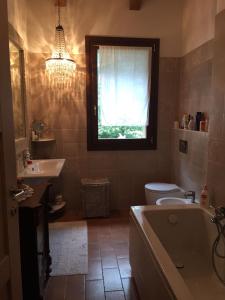 bagno con vasca, servizi igienici e finestra di Casa Madonna Boschi a Poggio Renatico