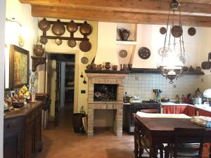 a kitchen with a stove and a fireplace with pots and pans at Casa Madonna Boschi in Poggio Renatico