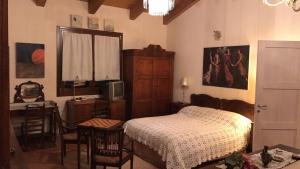 a bedroom with a bed and a desk and a television at Casa Madonna Boschi in Poggio Renatico