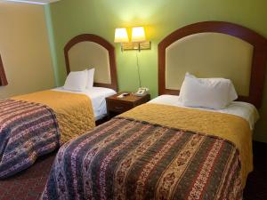 a hotel room with two beds and a phone at PATRIOT INN in Spencer