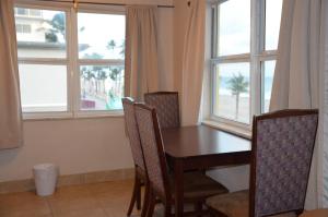 a dining room with a table and chairs and windows at La Terrace Oceanfront in Hollywood