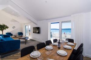 uma sala de jantar com mesa e cadeiras e uma sala de estar em Seafront Luxury Apartments Fun em Trogir