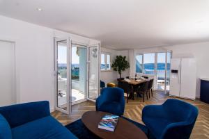 sala de estar con sofá azul y mesa en Seafront Luxury Apartments Fun, en Trogir