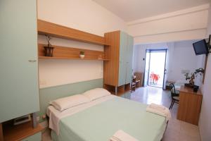 - une chambre avec un grand lit blanc et une télévision dans l'établissement Hotel Atlantic, à Senigallia