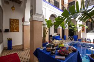 a table with plates of food on it next to a pool at Riad Ciel d'Orient in Marrakesh