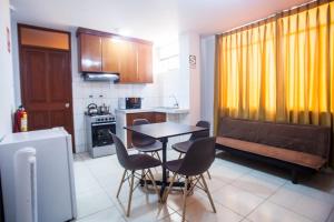 a kitchen with a table and chairs and a bench at Hostal Vasco in Tacna