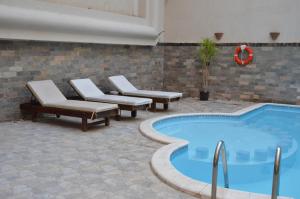 Elite Suites Hurghada في الغردقة: مسبح وكراسي صالة ومسبح
