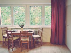 ein Esszimmer mit einem Tisch, Stühlen und Fenstern in der Unterkunft Apartment Mida in Freiburg im Breisgau