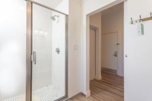 a shower with a glass door in a bathroom at Ocean View Inn in Montara