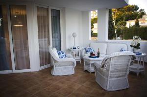 eine Terrasse mit weißen Korbstühlen und einem Tisch in der Unterkunft LUXURY 2-bed apartment with big terrace in aparthotel with outdoor pools in CALAHONDA in Sitio de Calahonda