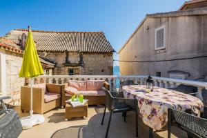 balcone con tavolo, sedie e ombrellone di Apartments Villa Mirakul a Kaštela (Castelli)