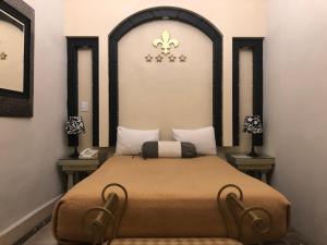 1 cama en una habitación con 2 lámparas en la pared en Hotel Elena en Puebla
