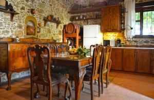 a kitchen with a wooden table with chairs and a refrigerator at Kamara Stone House in Kissamos