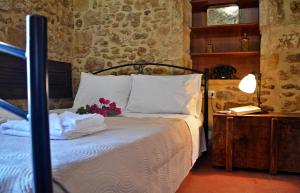a bedroom with a bed with towels and flowers on it at Kamara Stone House in Kissamos
