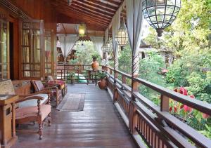 a porch of a house with chairs and tables at Badjoeri Ethnic Wooden Homestay in Bandung