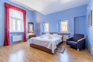 a blue bedroom with a bed and a chair at Hotel U Rytíře in Mělník