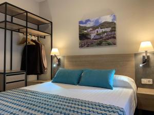 una camera da letto con un grande letto con cuscini blu di Mar de las Calmas a La Restinga