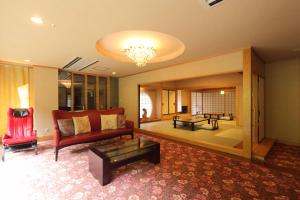 a living room with a red couch and a table at Hotel Futaba in Yuzawa