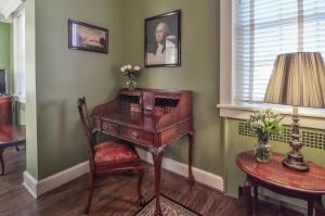 een kamer met een bureau, een stoel en een lamp bij Cedars of Williamsburg Bed & Breakfast in Williamsburg