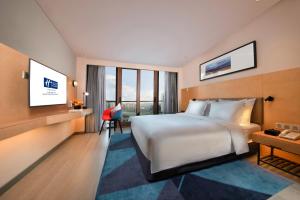 a hotel room with a large bed and a desk at Holiday Inn Express Beijing Shijingshan Parkview, an IHG Hotel in Beijing