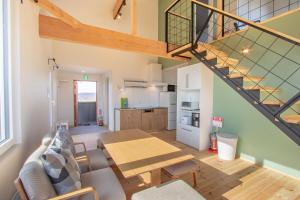 a living room with a table and a staircase at Niseko Highland Cottages in Niseko