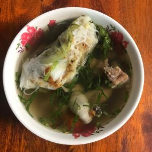 a bowl of chicken soup with rice and vegetables at Chansor Homestay 13 By Siem Reap Homesteading in Siem Reap