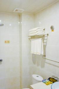 La salle de bains est pourvue d'une douche, de toilettes et de serviettes. dans l'établissement Xing Xin Hotel, à Dunhuang