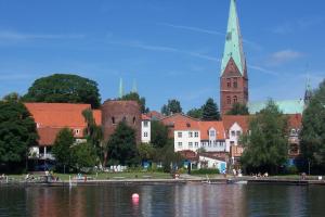 a view of a town with a church and a river at Gästehaus am Krähenteich in Lübeck