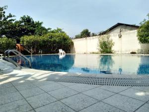 uma piscina vazia com cerca e árvores em Excelsior Resort em Dili