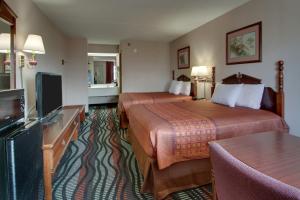 a hotel room with two beds and a flat screen tv at Angel Inn - Central in Branson