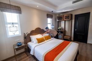 Postel nebo postele na pokoji v ubytování Sanouva Saigon Hotel
