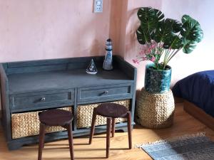 a bedroom with a dresser with two stools and a plant at Sea Urchin Homestay in Phan Rang