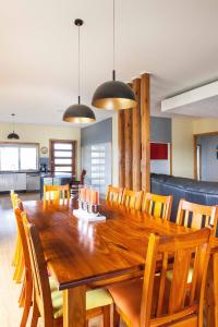 a dining room with a wooden table and chairs at Wheel chair & Pet Friendly Waterfront Retreat, 10 minutes to Phiilip Island, fireplace, wood supplied, WIFI wine & chocolates in Kilcunda