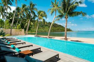 einen Pool mit Liegestühlen und Strand in der Unterkunft Avani Plus Samui Resort in Taling Ngam Beach