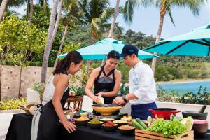 a group of people standing around a table with food at Avani Plus Samui Resort in Taling Ngam Beach