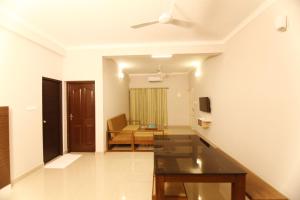 a living room with a couch and a ceiling fan at Castilo Inn Hotel Apartments in Cochin