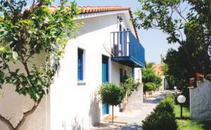 a white house with a blue balcony on a street at Green Village in Xylokastro