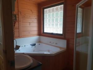 a bathroom with a tub and a sink and a window at Kiramli Villas in Halls Gap