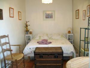 a bedroom with a bed and a chair and a table at La Mesnagerie in Jarzé