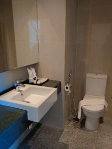 łazienka z białą umywalką i toaletą w obiekcie Paya Bunga Hotel w mieście Kuala Terengganu