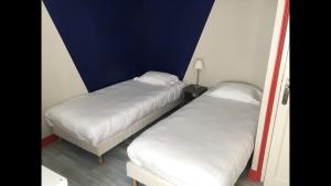 two beds sitting next to each other in a room at Gite le Petit Puits à Richelieu in Richelieu