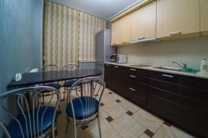 uma cozinha com uma mesa e cadeiras e um frigorífico em Kvartirkoff na Bogatirskaya 6a, 2 floor em Kiev